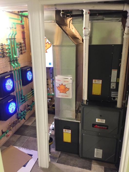 Neatly organized HVAC system in a British Columbia mechanical room, featuring labeled units, color-coded pipes, and tiled flooring.